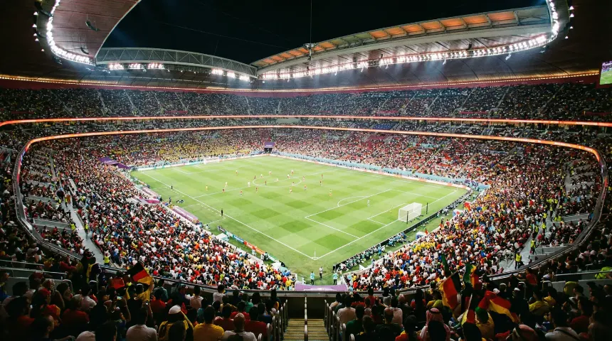 Estadio iluminado durante un partido nocturno del Mundial 2026 con tribunas llenas de aficionados